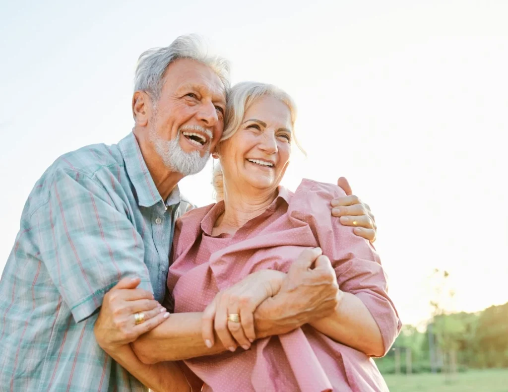 Old man and old woman hugging each other while smiling