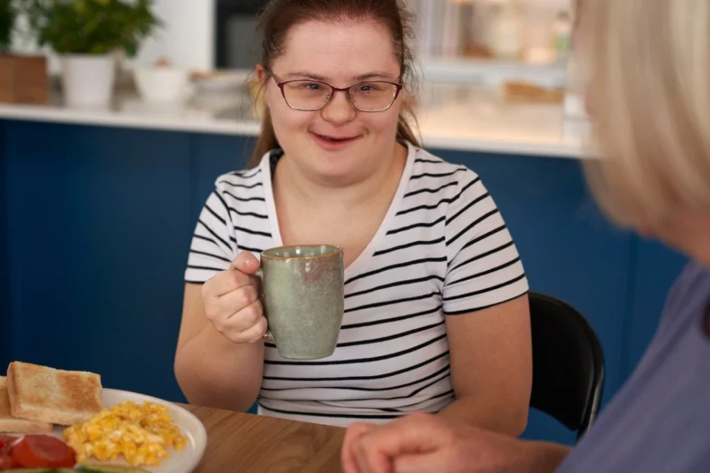 A disabled woman smiling while holding a coffee cup