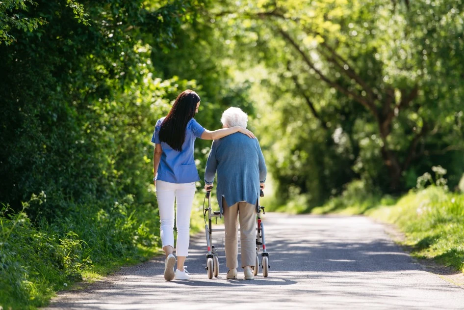 Old woman and her support worker going for a walk